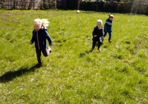 Przedszkolaki biegają po trawie